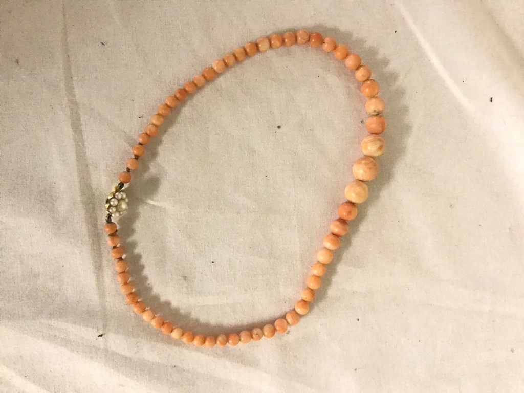 A 9ct pearl clasped string of coral beads