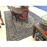 A large Persian rug decorated in blues & cream