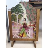 A painted firescreen oil on board of a woman in a garden,