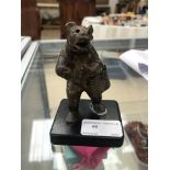 A bronze bear carrying a handbag,