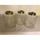 A set of three cut glass cannisters with brass lids