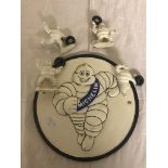 A Michelin Man cast-iron plaque with miniature Michelin Man figures