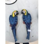 A pair of cast-iron decorative wall hanging parrots