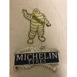 Two cast metal Michelin Man signs