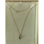 An 18k gold necklace with a diamond & sapphire pendant