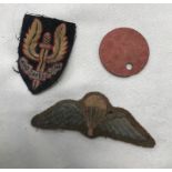 An SAS beret badge and parachute jump wings;