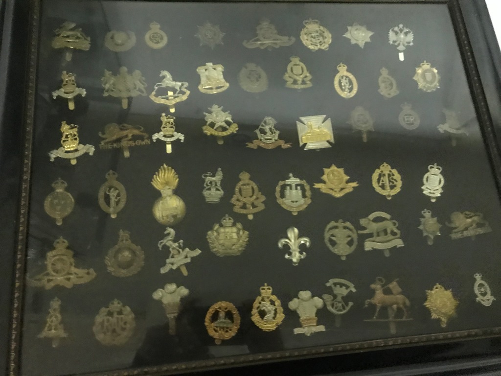 A framed collection of cap badges