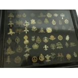 A framed collection of cap badges