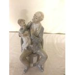 A Lladro figure of a man with a child on his lap