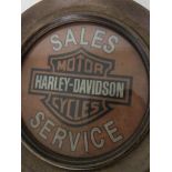 A Harley Davidson advertising sign in a wooden frame
