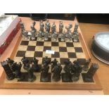 A cast metal chess set and board with Ancient Roman/Greek warriors