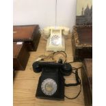An ivory bakelite telephone together with a black bakelite telephone