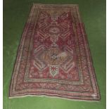 A red ground wool runner, 290cm x 135cm