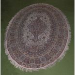 An oval wool rug, 240cm x 135cm