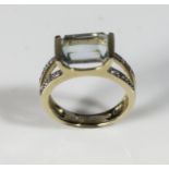 A lady's 18ct gold ring with diamond chips to shoulders, set with an aquamarine, boxed. size M