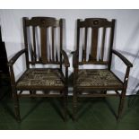 A pair of Edwardian oak arm chairs.