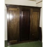 A three door mahogany wardrobe with fitted sliding drawers.