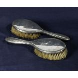 two silver backed brushes