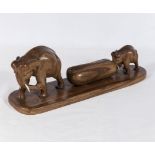 A vintage teak carving of elephants moving timber