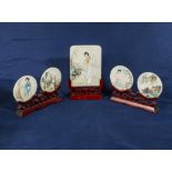 Hand painted Japanese figures on marble tablets on carved wooden stands, the tablet size of centre