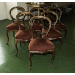 A set of six Victorian walnut balloon back chairs on cabriole legs.