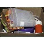 A box containing plastic kitchen containers and tea towels