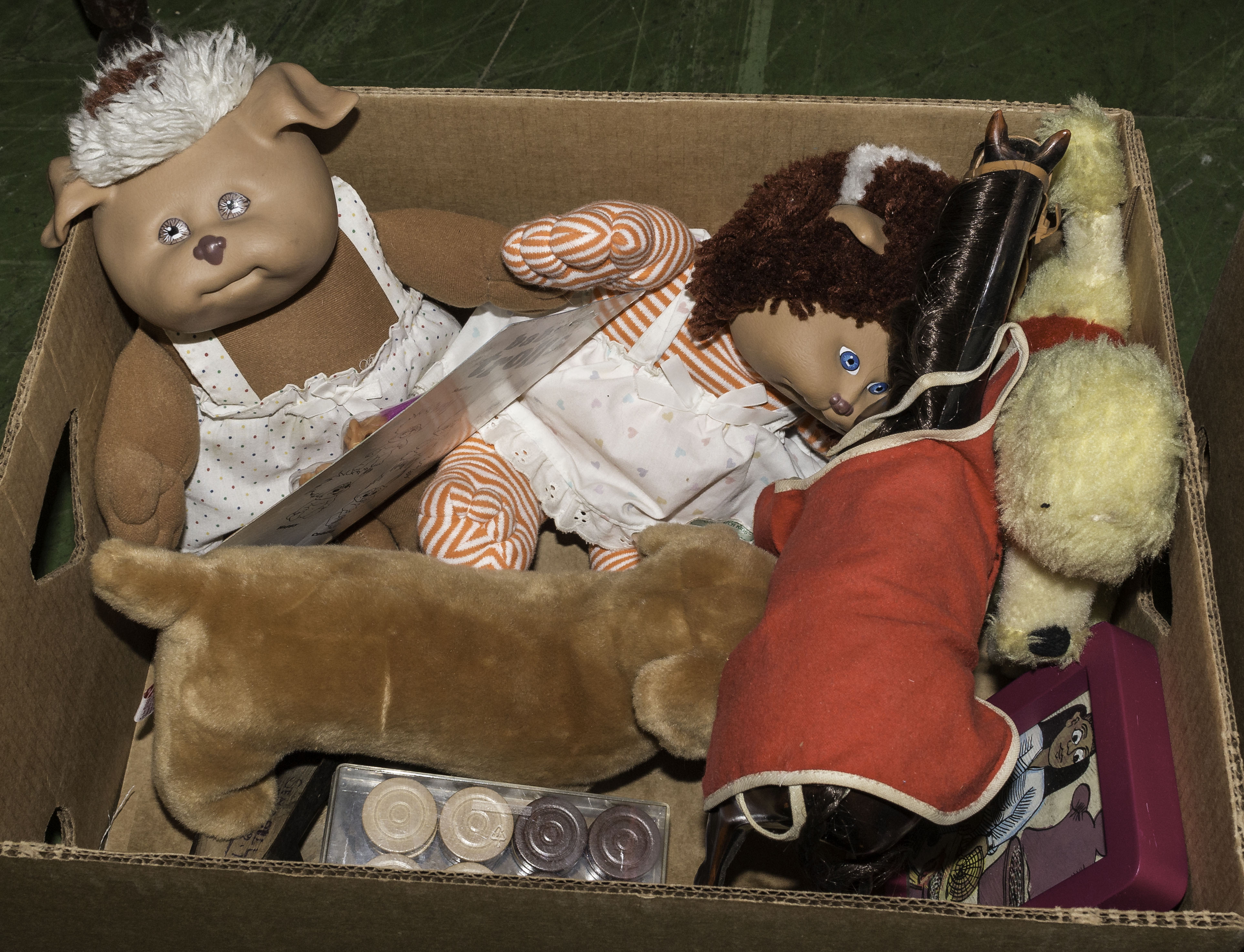 A box containing dolls and plush toys