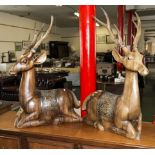 A pair of large carved wooden deer