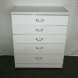 A white chest of five drawers