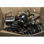 A box containing saucepans and teapots