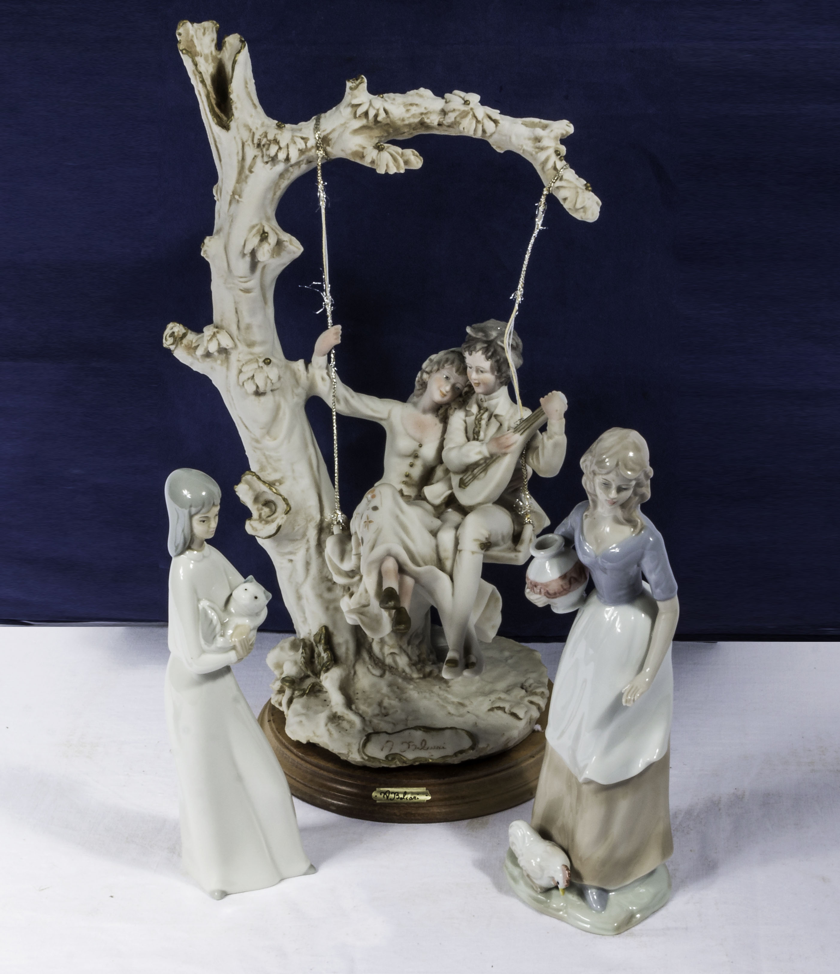 A figure group together with two Lladro style figure