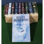 A box containing Kelly Armstrong books