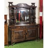 An arts and crafts sideboard with mirror and copper panels to the back