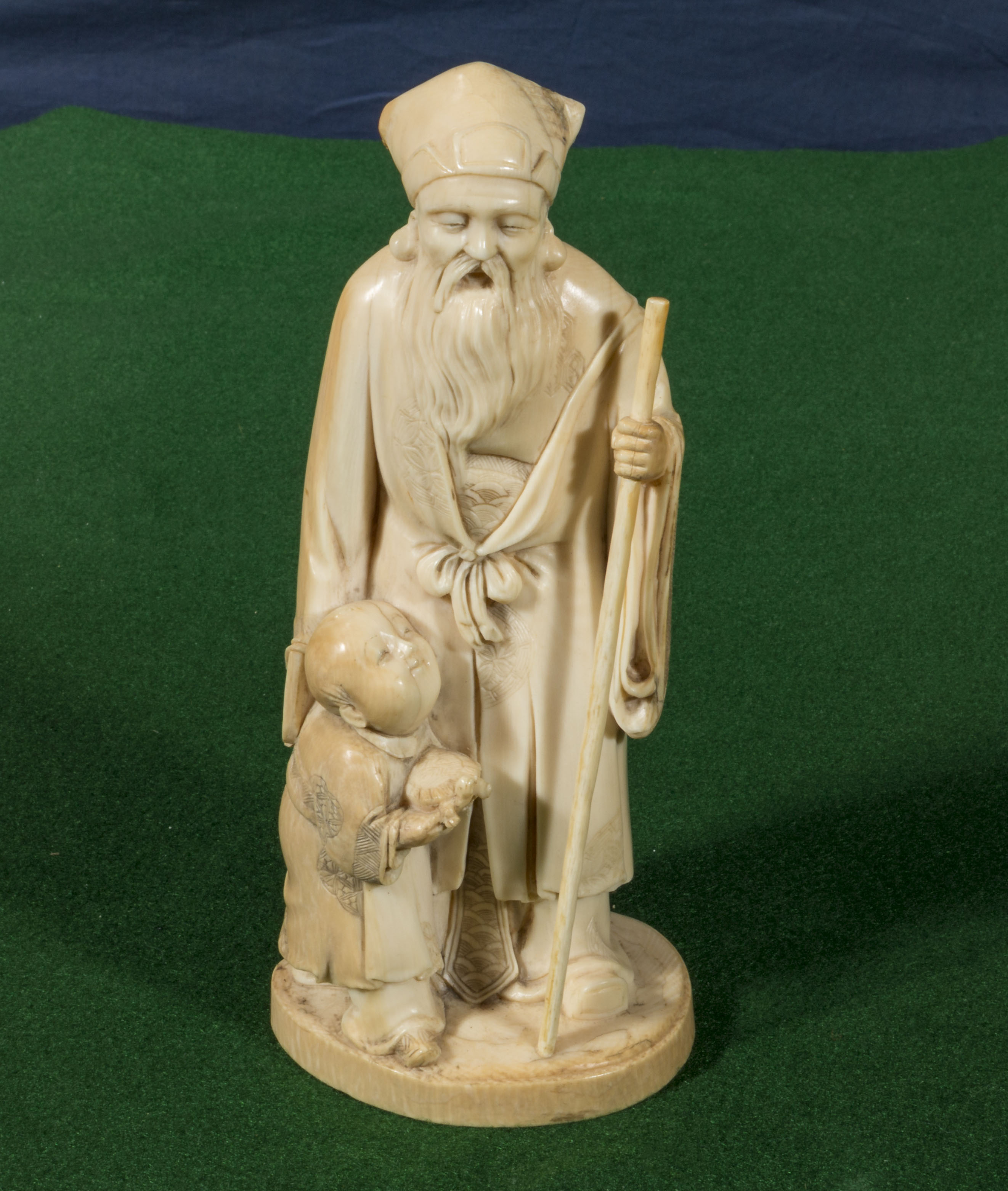 A Chinese ivory figure man with staff and boy holding a turtle (18cm tall)