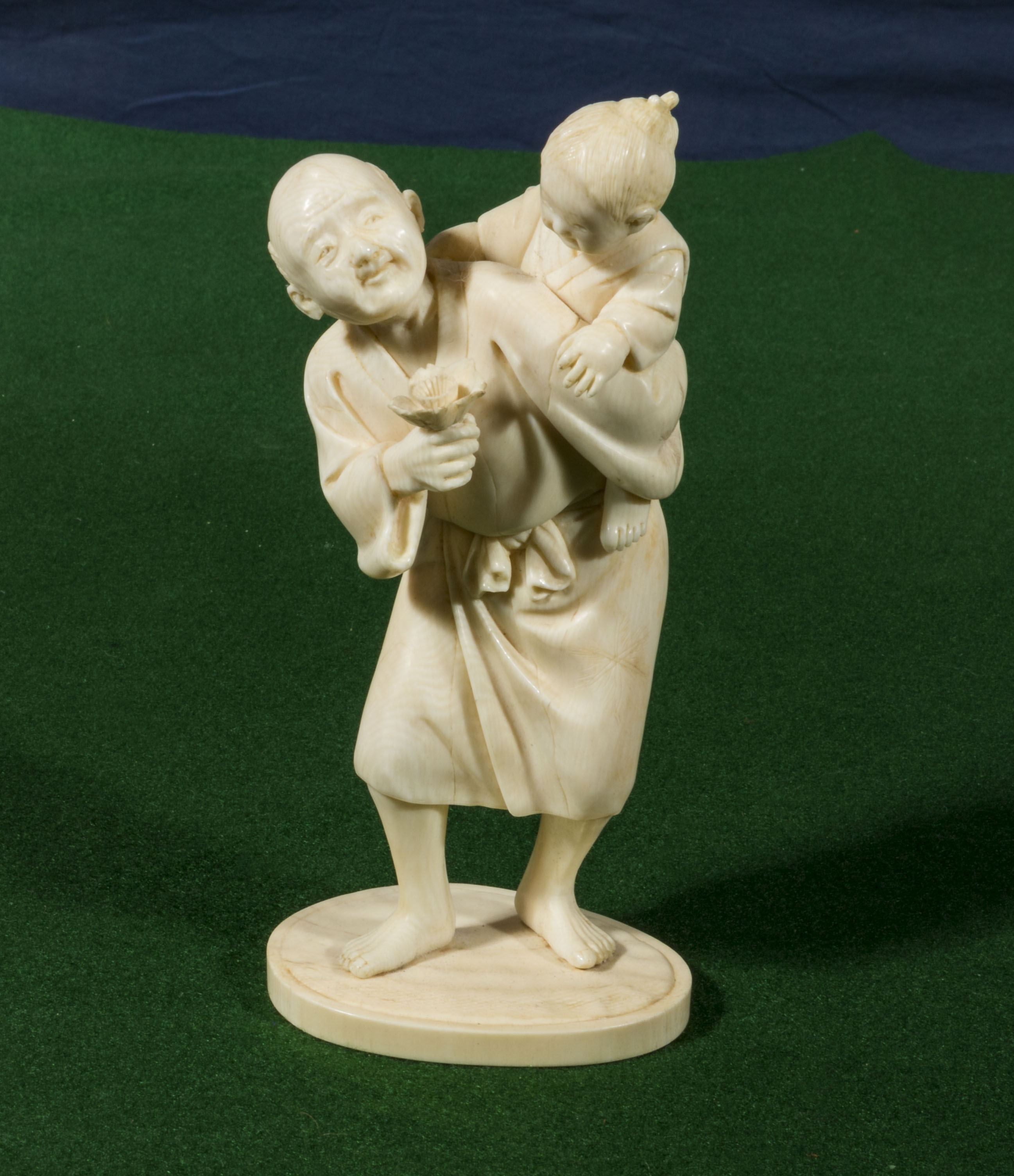 A Chinese ivory of man carrying a child (15cm tall)