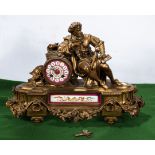 A French ormolu mantle clock with porcelain panels and a recumbent gentleman