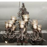 A large polished steel light fitting in the Art Nouveau style, with 10 branch glass lights and amber
