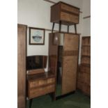 A three piece 1960's retro bedroom suite comprising single wardrobe, chest of drawers and dressing