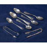 A selection of silver spoons and tongs and others