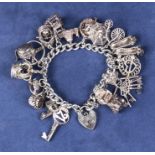 A silver charm bracelet with 18 charms. 92gms