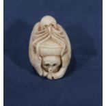 A signed ivory netsuke of an octopus with fish