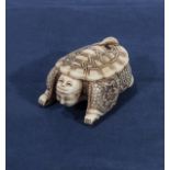 A signed ivory netsuke of an actor with a turtle shell