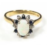 An 18ct yellow and white gold opal, diamond and sapphire cluster ring, size P