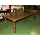 A Victorian oak wind out table with two extra leaves