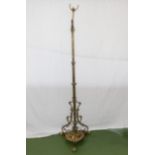 An Art Nouveau brass standard lamp supported by three paw feet