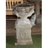 A reconstituted stone urn on stand