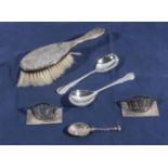 Two silver place settings, spoons and a hairbrush