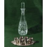 A glass decanter and six silver plated shot cups and tray