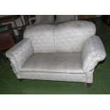 A two seater Howard & Son drop end couch, stamped on inside of back leg. Not original castors