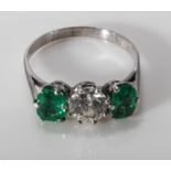 An 18ct white gold three stone emerald and diamond (70pt) ring